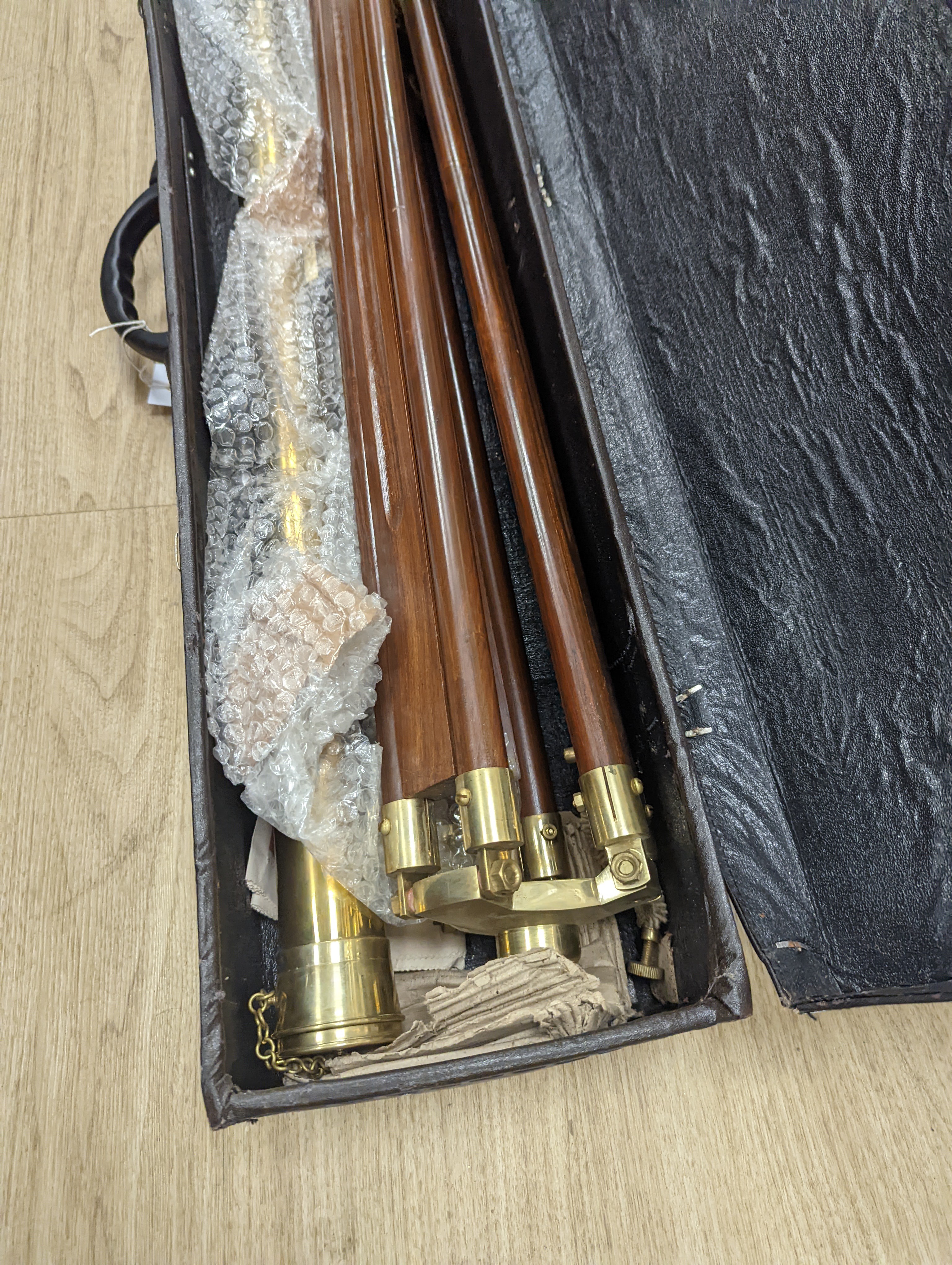 A cased brass telescope and tripod stand